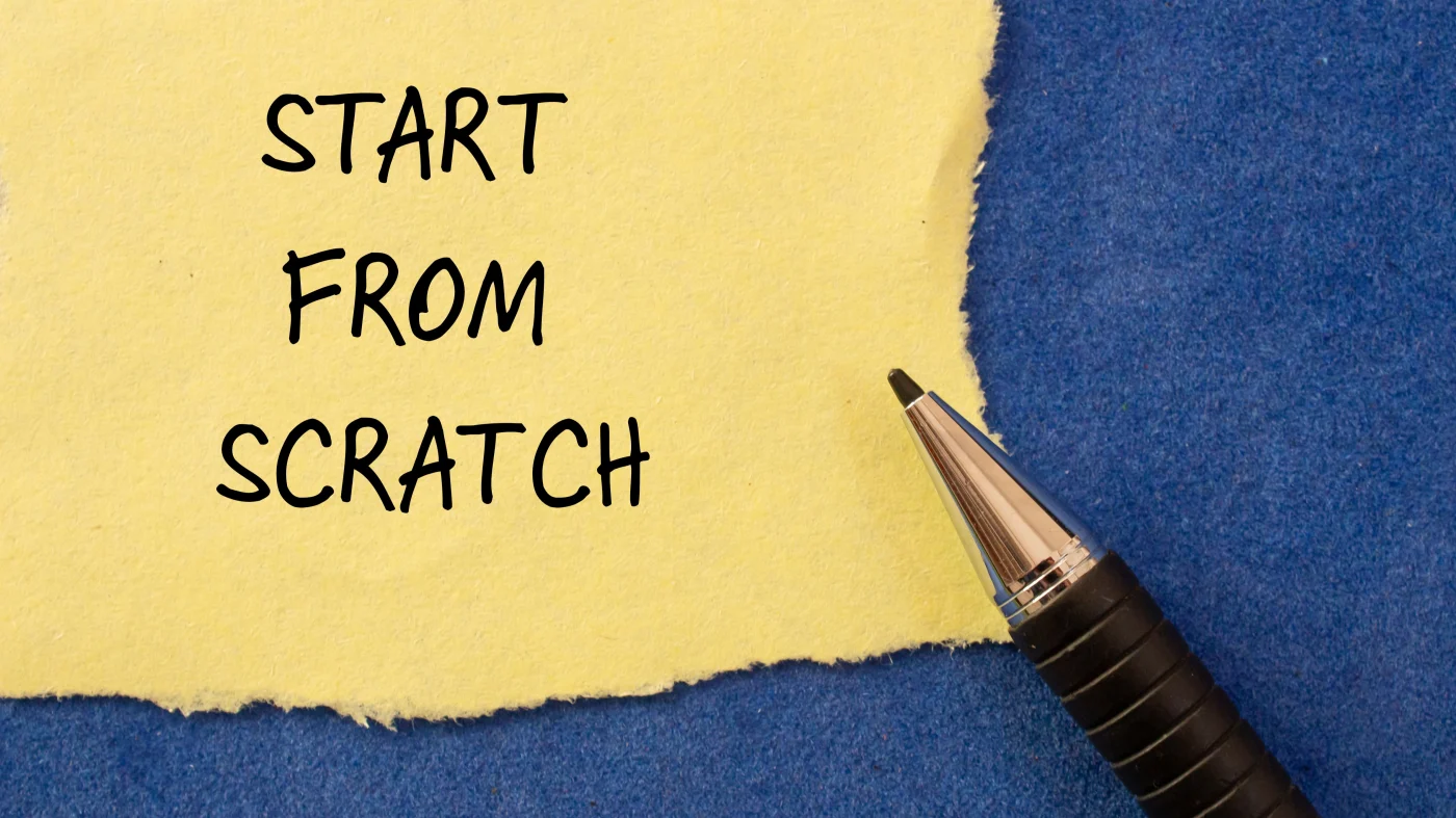 The phrase “start from scratch” is written on torn tan paper against a dark blue background.