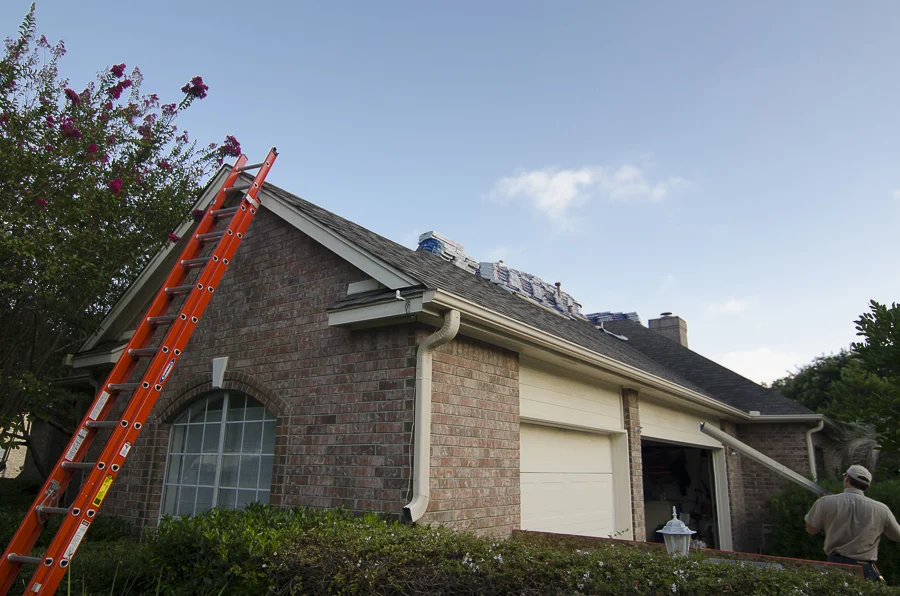 Exceptional Residential Roof Replacements In Austin, TX | Freetail Roofing Roofers installing a new asphalt shingle roof on a brick house.