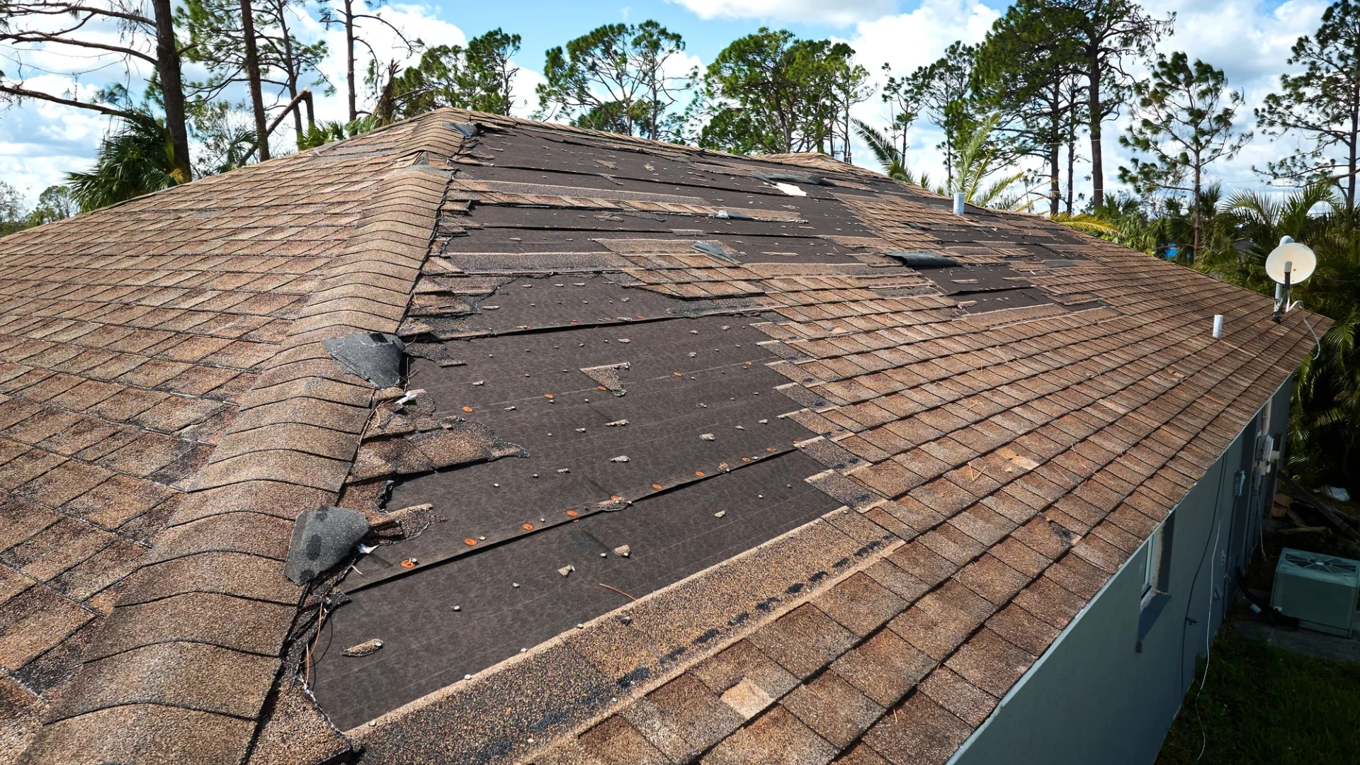 Roof with missing shingles due to high winds