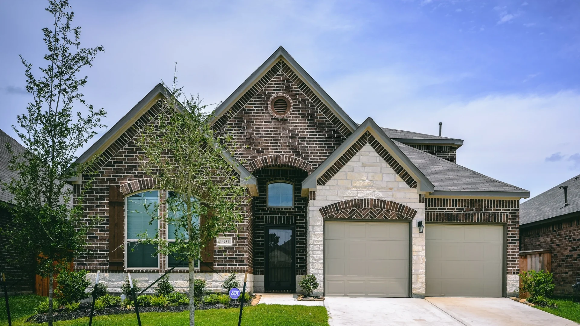 Stone house with asphalt shingle roof in residential neighborhood