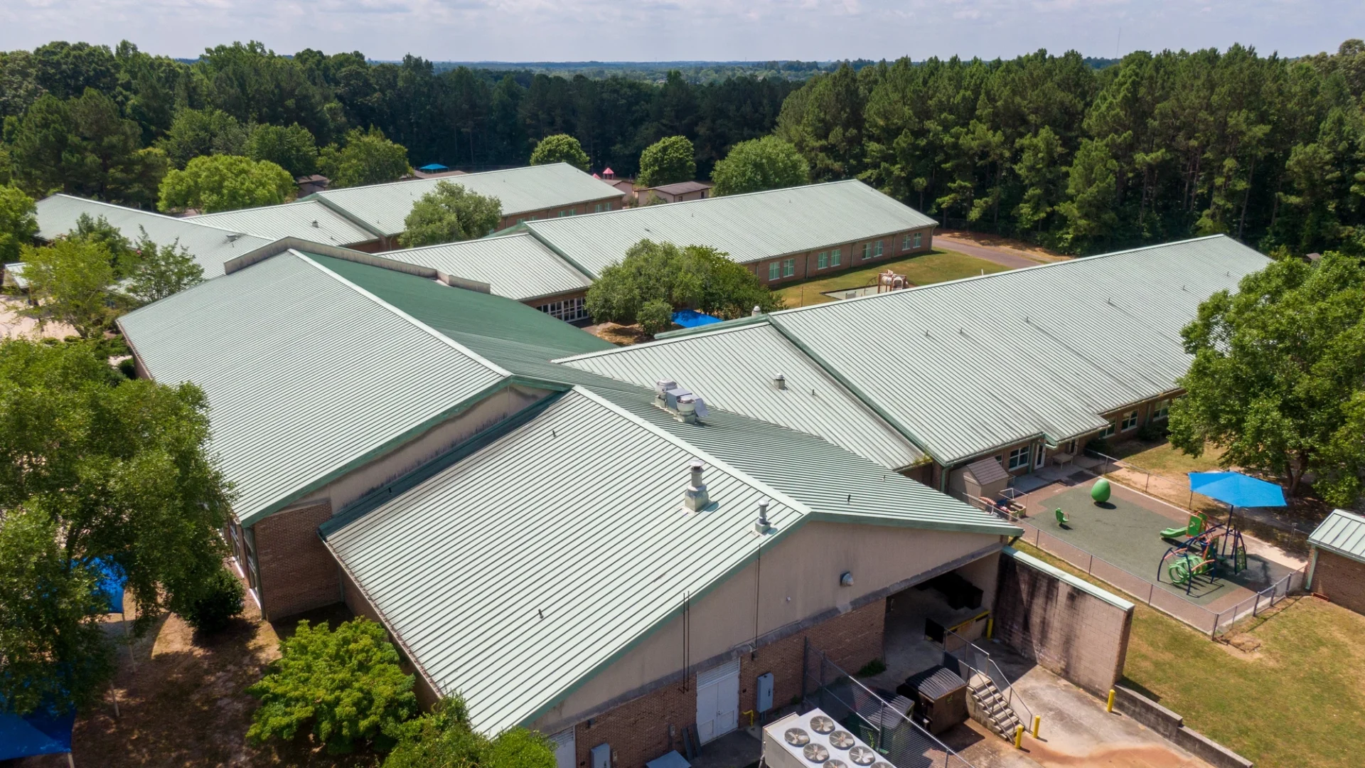 Aerial view of green standing seam metal roof on commercial building