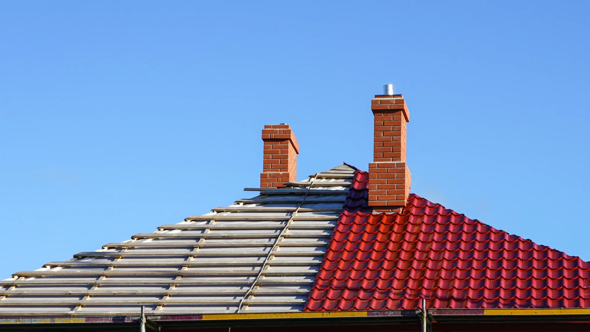 Half-finished roof replacement with red tiles