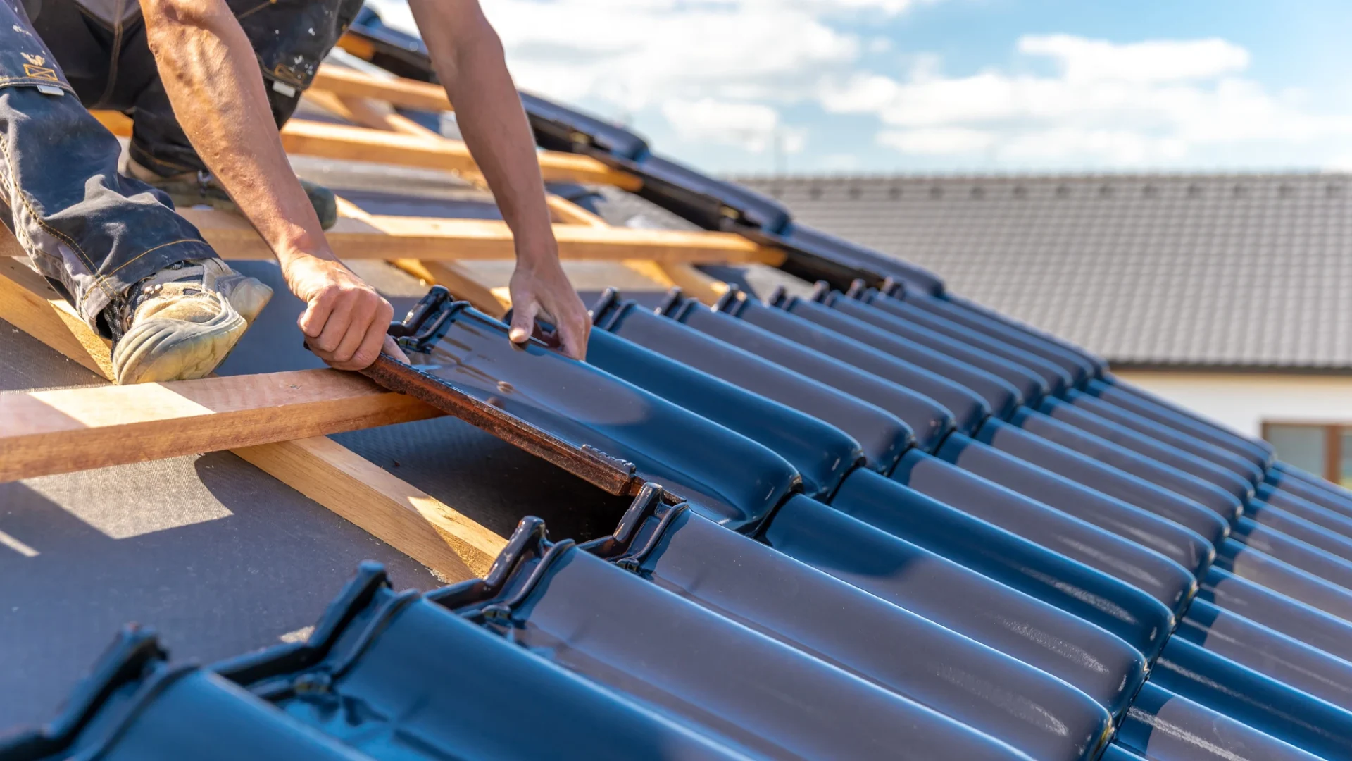 Detailed view of a roofer in the process of installing a new tile roof