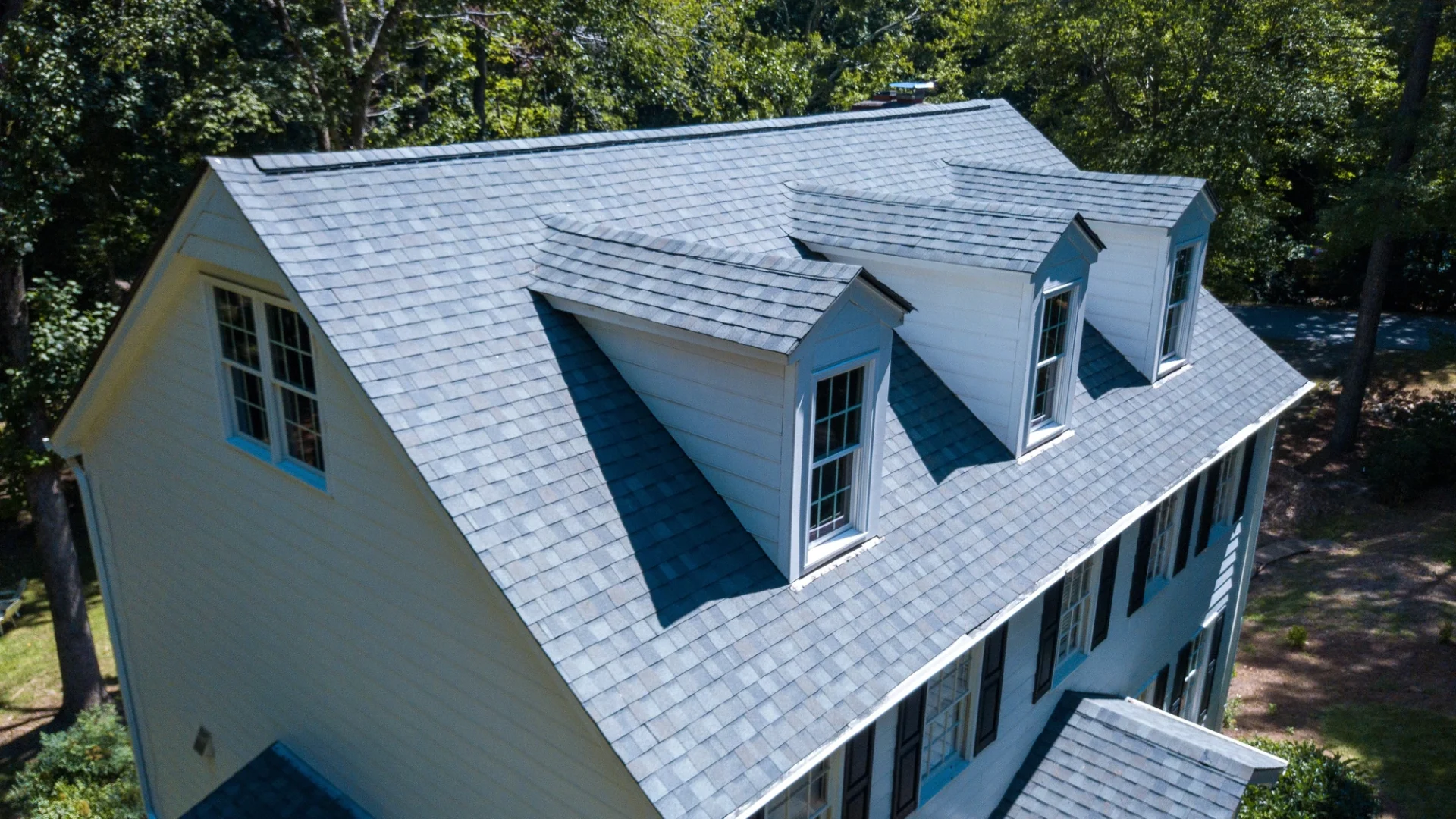 Elevated view of a beautiful asphalt roof on a large suburban home