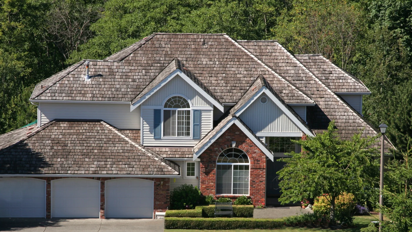Beautiful two-story brick home with brown cedar shake wood roof