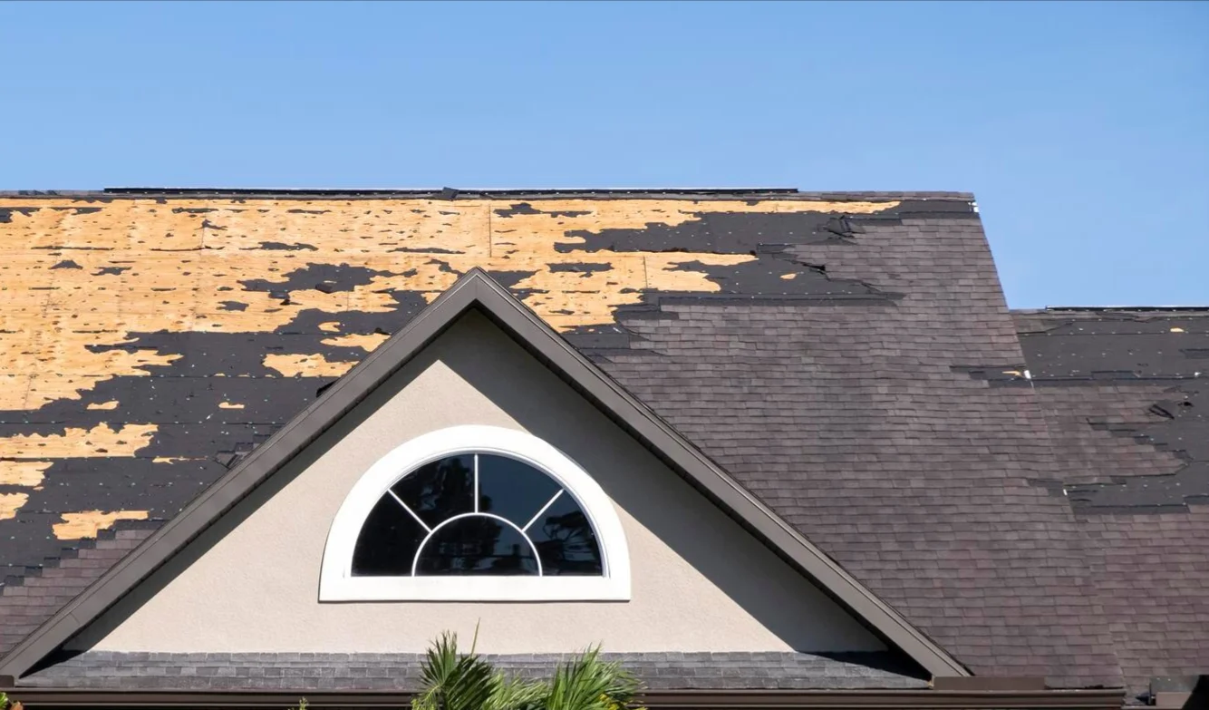 Home Services | Burnet, TX | Freetail Roofing Close-up image of a roof with about half the shingles stripped off by a storm in Burnet,TX | Freetail Roofing