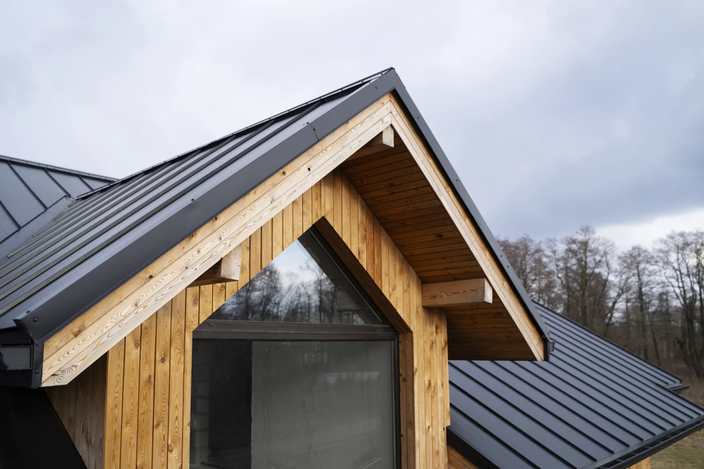 Close-up of a dormer with a black, metal roof.