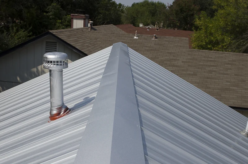 A view atop a metal roof looking towards the edge of the house.