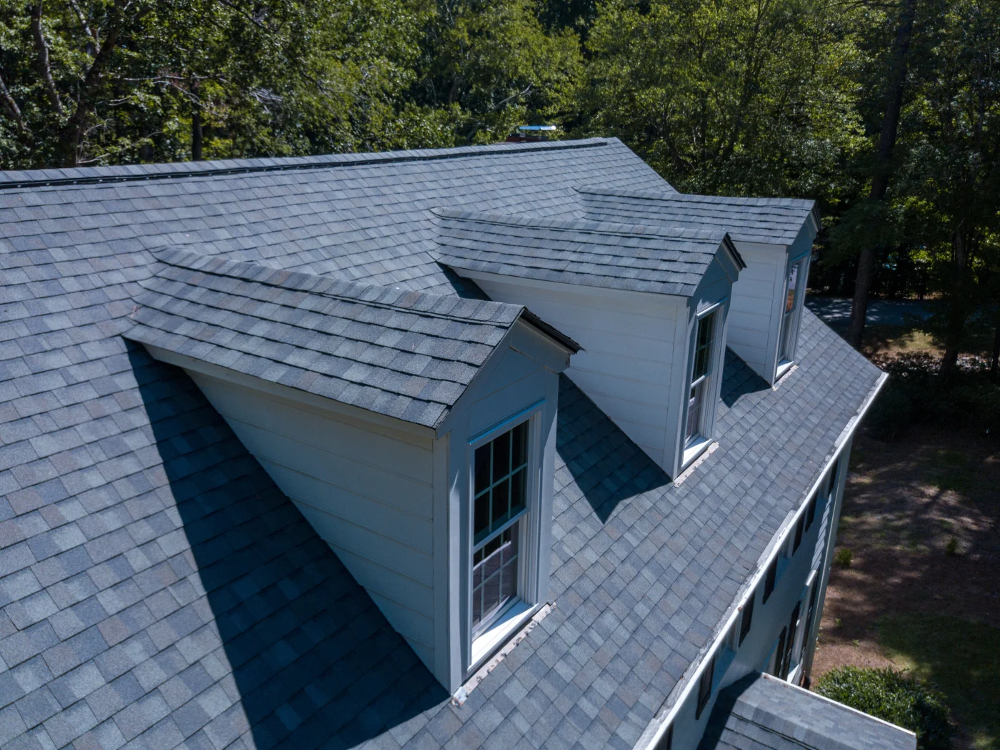 Drone view of a large house with new asphalt shingles.