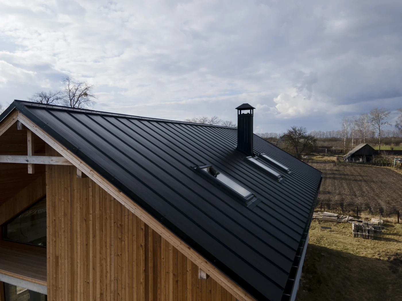 A large home with skylights, a chimney, and metal roofing.